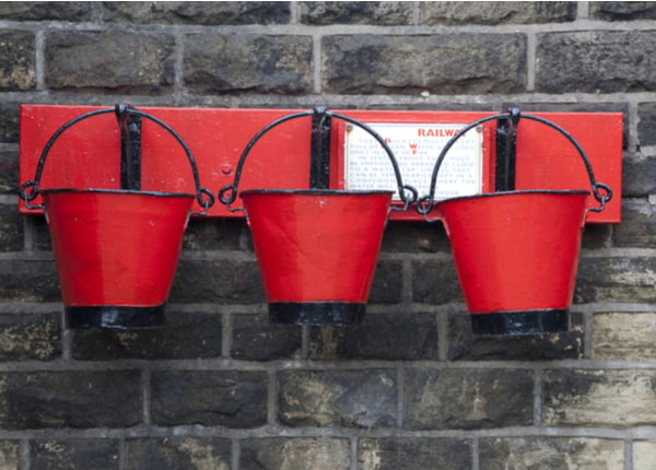Three old red fire buckets