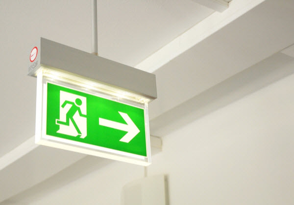 Green emergency exit sign showing the way to exit