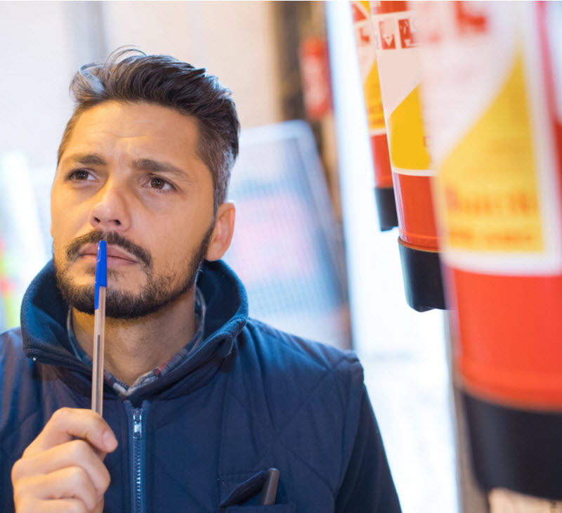 man thinking about fire extinguisher